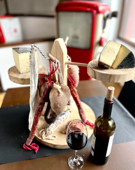 Torre de embutidos ibéricos y queso sobre soporte de madera