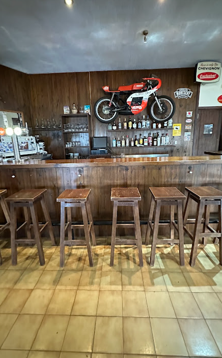 La barra de madera con la Yamaha de carreras montada encima y los taburetes