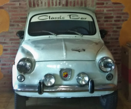 El SEAT 600 Abarth blanco Classic Bar contra la pared de ladrillo