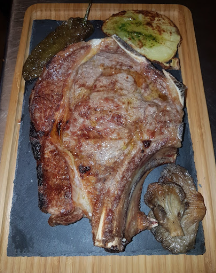 Entrecot sobre pizarra negra con pimiento y champiñón